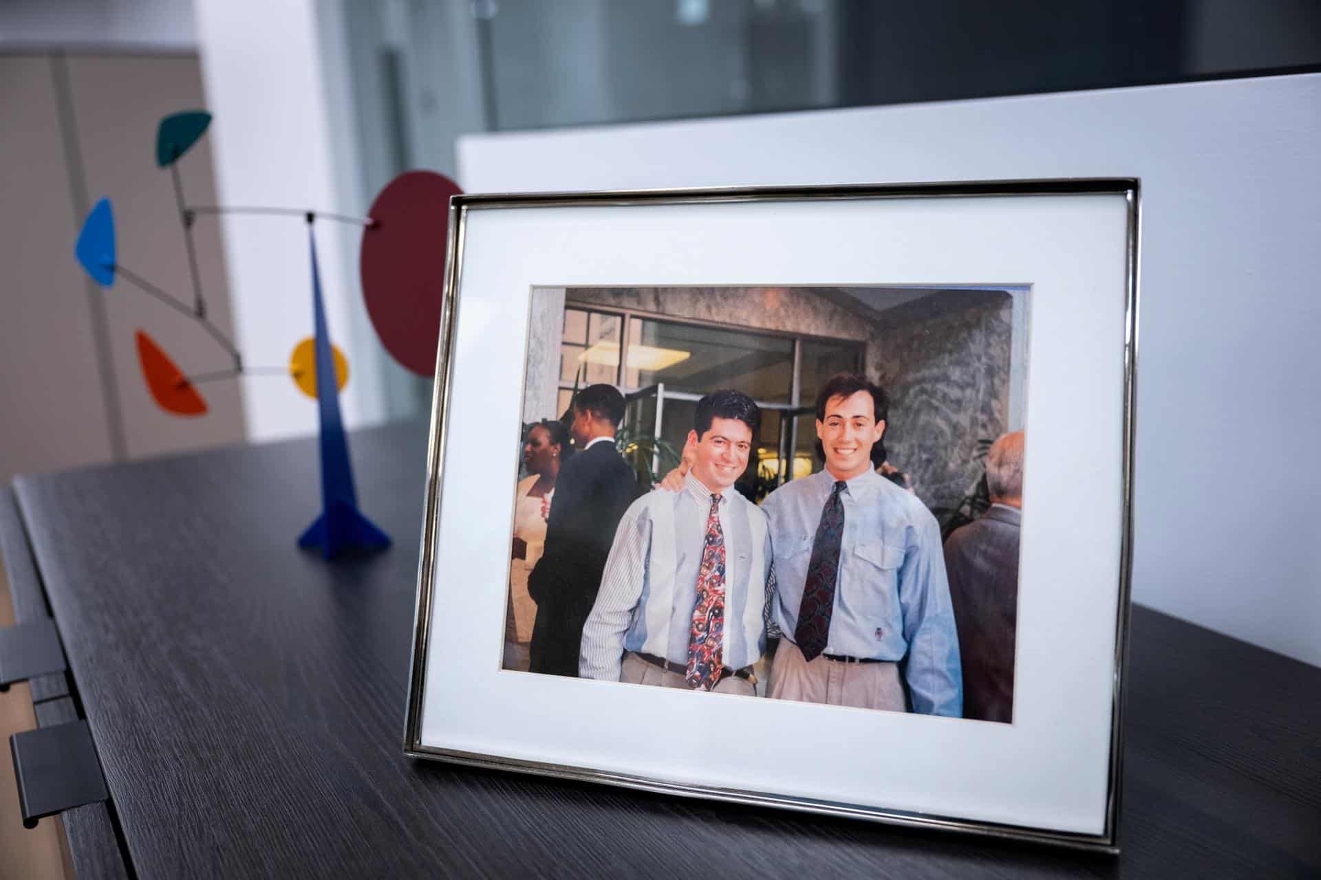 Image of framed photograph of young, college age Howard I. Elman and Jay W. Freiberg (left to right) in blue shirts and colorful ties.