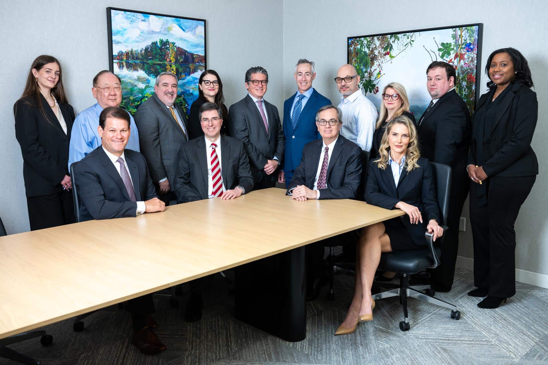 Group image of Elman Freiberg employees both standing and sitting in conference room, all looking at camera.